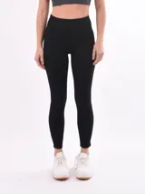 Calza deportiva negra de tiro alto, ajustada al cuerpo, con pequeños detalles de costura en los laterales.