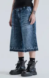 Bermuda larga de denim con calce oversize, desgaste y ruedo desflecado.