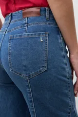 Jean de mezclilla azul medio, tiro alto, corte wide leg con costuras verticales marcadas en el frente de las piernas.