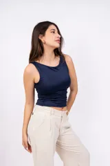 Musculosa blanca ajustada al cuerpo, con cuello redondo y sisas amplias.