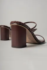 Sandalias de tacón color marrón chocolate con capellada trenzada, punta cuadrada y dos tiras finas sobre el empeine. Tacón cuadrado.