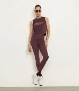 Legging deportiva ajustada al cuerpo, color morado oscuro, con cintura alta y bolsillo pequeño en la espalda.