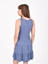 Vestido corto color coral, de corte suelto y sin mangas, con escote en V y falda escalonada con volantes.