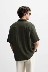 Camisa verde militar de manga corta con cuello bowling, corte relaxed fit y cierre frontal con botones.