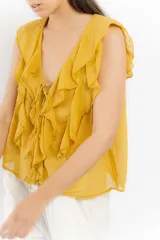 Blusa blanca de algodón con escote en V, volados en el frente y mangas cortas.