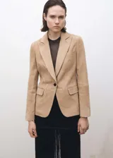 Blazer color beige de corte entallado, con solapas de muesca, cierre frontal con un botón, bolsillos con solapa y mangas largas.