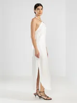 Vestido largo blanco de lino italiano con hilo metalizado y escote halter ajustable con cordón.