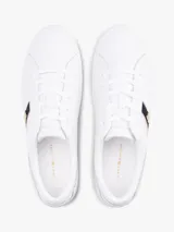 Zapatillas de corte bajo confeccionadas en piel napa color blanco. Presentan una franja lateral de tejido trenzado con los colores distintivos de la marca y una insignia metálica con el monograma TH. Cuentan con cordones al tono, suela de goma vulcanizada y logo en relieve en el talón.