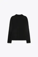 Chaqueta tipo blazer de punto color negro, con cuello solapa, manga larga, falsos bolsillos delanteros con tapetas y cierre frontal con botones dorados.