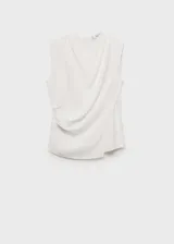 Blusa blanca sin mangas de tejido fluido con diseño cruzado y cuello redondo. Presenta cierre de cremallera en la parte posterior y detalles drapeados.