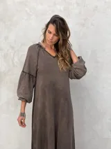 Vestido largo color marrón, de corte suelto, con mangas largas abullonadas y escote en V.