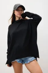 Sweater negro de corte holgado con cuello alto y mangas largas, ideal para combinar con shorts.