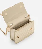 Bolso transversal pequeño color dorado, con correa de cadena y colgante redondo. Textura capitoneada, efecto metalizado y separador interior con cierre.