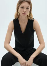 Chaleco negro de vestir con cuello en V, sin mangas y cierre frontal con botones. Presenta dos bolsillos delanteros de ribete y forro interior.