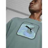 Remera verde de algodón con estampado de una ola y el logo de Puma en negro.