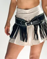 Cinto ancho de cuero sintético negro con tachas plateadas y flecos largos.