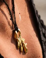 Collar con dije de bronce macizo con forma orgánica o de coral, suspendido de un hilo de seda natural color naranja.