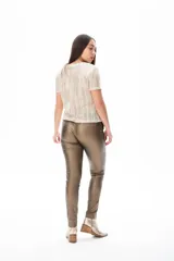 Blusa color dorado de tejido calado con mangas cortas y cuello redondo.
