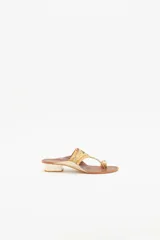 Sandalia de cuero color marrón con bordados de hilo y lentejuelas doradas. Tiene taco cuadrado color hueso de 3 cm de altura.