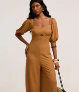 Mono pantalón largo color marrón, con escote corazón, mangas abullonadas 3/4 y abertura en el abdomen.