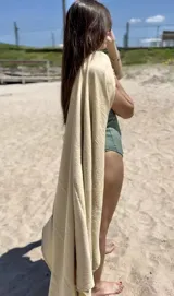 Manta de playa color beige, ideal para cubrirse del sol o como toalla.