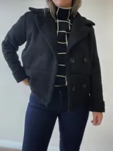 Chaqueta marrón con forro tipo corderito, doble botonadura y cuello con solapas.