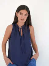 Musculosa color verde militar con cuello redondo y lazo marrón en el escote.