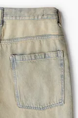 Pantalón de jean celeste con efecto desgastado, corte holgado, tiro bajo y cinco bolsillos.