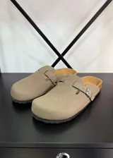 Zuecos color beige con hebilla lateral ajustable y plantilla anatómica.