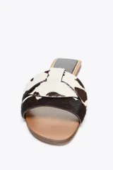 Sandalias planas con estampado animal, confeccionadas en piel con pelo. Presentan tiras cruzadas en la parte delantera y acabado en punta redonda. La altura de la suela es de 1 cm.