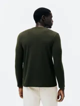 Remera verde militar de manga larga con estampa rectangular frontal de una moto antigua.