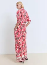 Pantalón de viscosa con estampado floral en tonos rojo, blanco y marrón. Tiene cintura elástica con cordón ajustable, corte recto y dos bolsillos laterales.