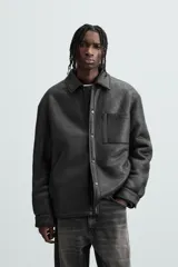 Sobrecamisa marrón de efecto piel con interior de borreguillo a tono, de corte relaxed fit, cuello solapa, manga larga con puños abotonados, bolsillos de plastrón en pecho y laterales, efecto lavado y cierre frontal con botones a presión.