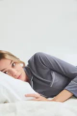 Pijama de viscosa y poliamida color gris con ribetes blancos, compuesto por camisa de manga larga con botones y pantalón largo.