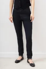 Pantalón de jean negro de corte skinny y tiro alto, confeccionado en gabardina con elastano y recubrimiento que simula cuero.