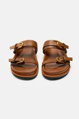 Sandalias planas negras con dos tiras anchas y hebillas doradas.