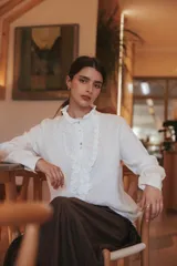 Camisa a cuadros marrón y beige, de algodón con cuello y pechera de tul bordado. Tiene botones de nácar en la cartera y los puños.