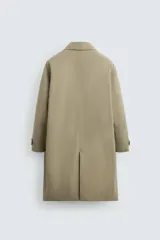 Gabardina color beige de corte recto, con cuello solapa, cierre frontal con botones, bolsillos laterales y puños ajustables con trabilla.