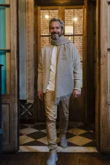 Campera tejida color beige con cierre delantero, cuello alto y bolsillos delanteros.