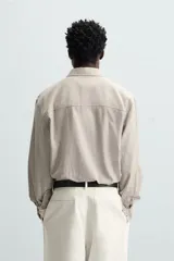 Camisa relaxed fit confeccionada en tejido con mezcla de algodón con tacto suave. Cuello solapa y manga larga acaba en puño con botón. Bolsillo plastrón en pecho. Cierre frontal de botonadura.