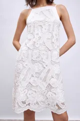Vestido corto blanco de broderie con breteles finos y corte recto.