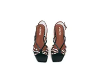 Sandalia de cuero negra con tiras finas y detalle frontal trenzado en colores blanco, marrón y negro. Pulsera ajustable con hebilla metálica y base plana con taco bajo geométrico.