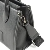 Cartera tote chica de símil cuero graneado color negro, con acceso por cierre y correa regulable con el logo de XL Extra Large estampado.