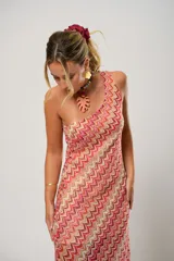 Vestido midi de tejido de punto con diseño de ondas en tonos rosa, rojo, beige y blanco. Tiene un solo tirante y corte al bies.