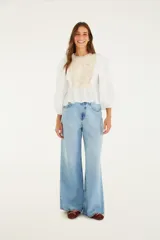 Pantalón de jean celeste de corte ancho, tiro alto y cinco bolsillos.