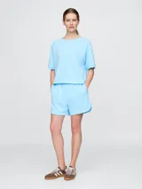 Short deportivo celeste con cintura elástica y logo de la marca bordado en la pierna izquierda.