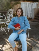 Camisa de denim celeste de algodón, de corte regular, con cuello clásico, mangas largas con puños abotonados, bolsillos con solapa abotonada en el pecho y cierre frontal con botones.