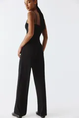 Pantalón negro de punto suave, tiro alto, cintura elástica y piernas amplias.