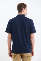 Remera manga corta verde con cuello polo y tapeta con botones.