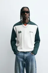 Camiseta de manga larga con cuello redondo, diseño color block en blanco y verde oscuro, con el número 80 y la inscripción 'Saint Frederic' bordados en el frente.